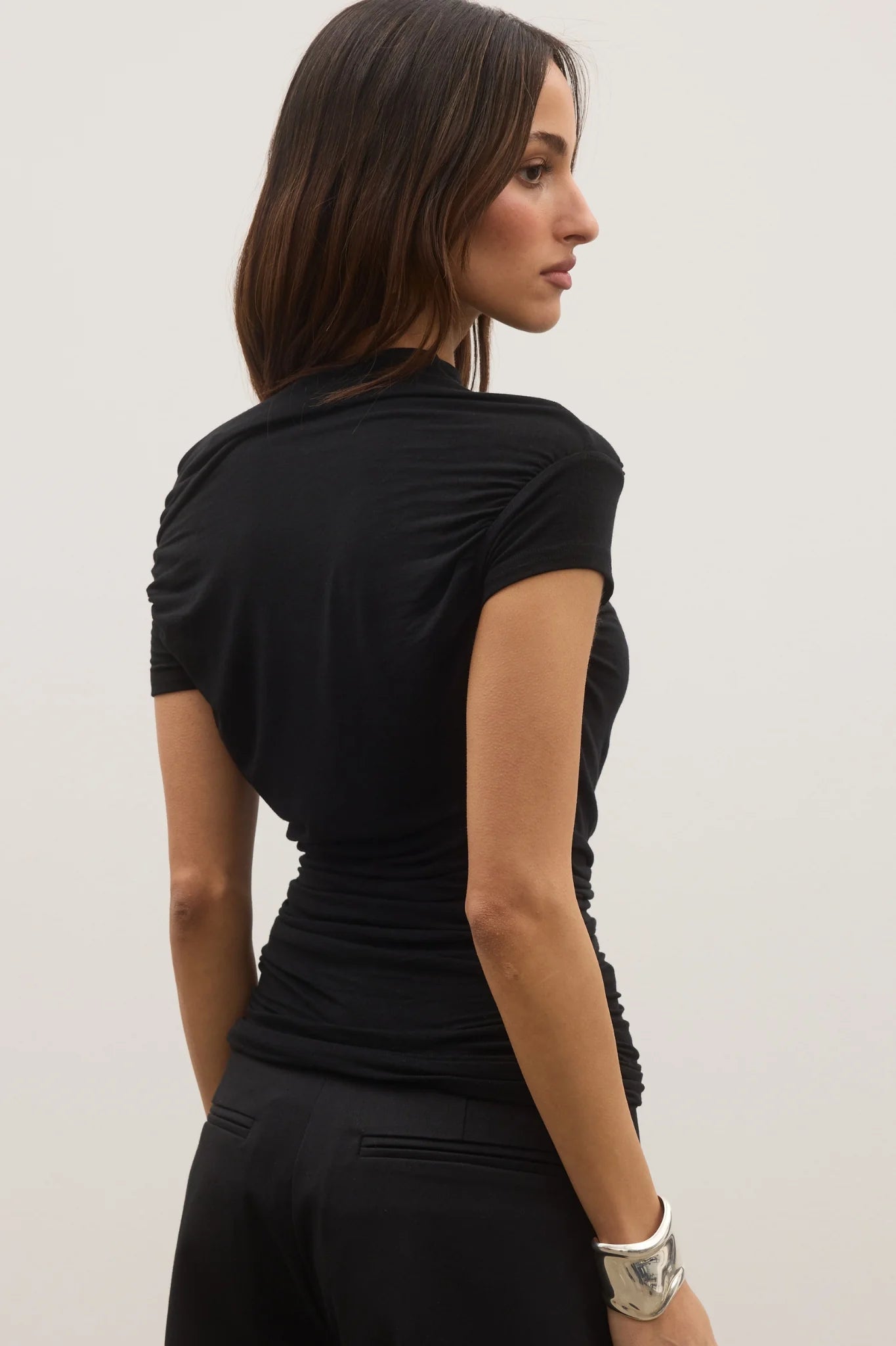 Woman wearing a black dress against a plain background