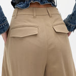 Person wearing beige pants and a blue denim shirt on a white background