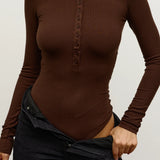 Brown long-sleeve top worn by a person on a plain background