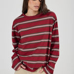Woman wearing a red and white striped sweater on a plain background