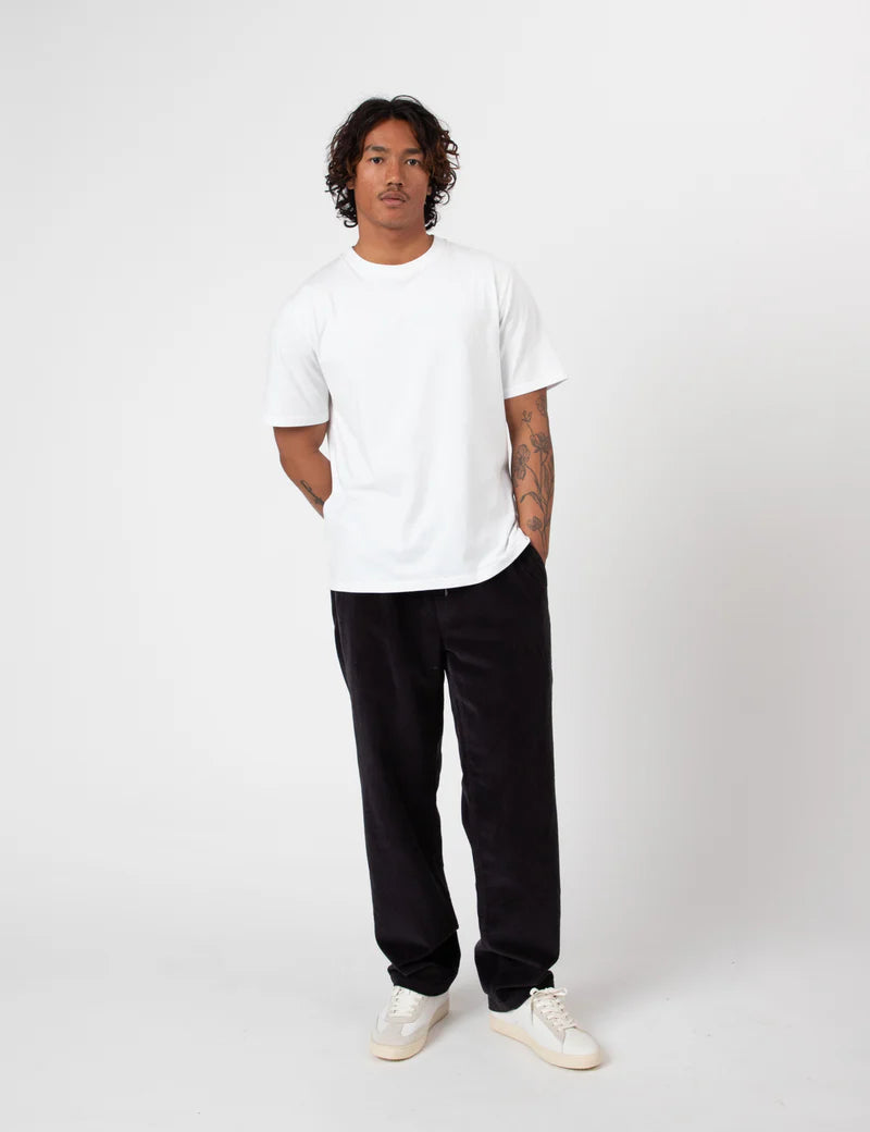 Person wearing a white t-shirt and Charcoal Cord pants on a white background