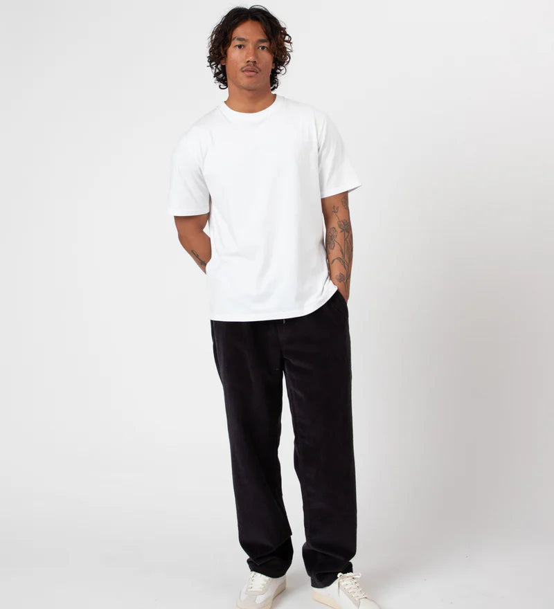 Person wearing a white t-shirt and Charcoal Cord pants on a white background