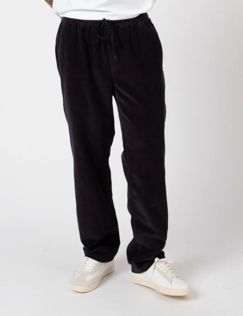 Black pants worn by a person on a white background