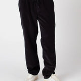 Black pants worn by a person on a white background