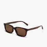Sunglasses with a clear frame and dark lenses on a white background