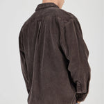 Man wearing a brown corduroy shirt on a white background