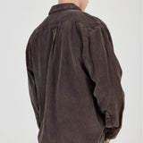 Man wearing a brown corduroy shirt on a white background