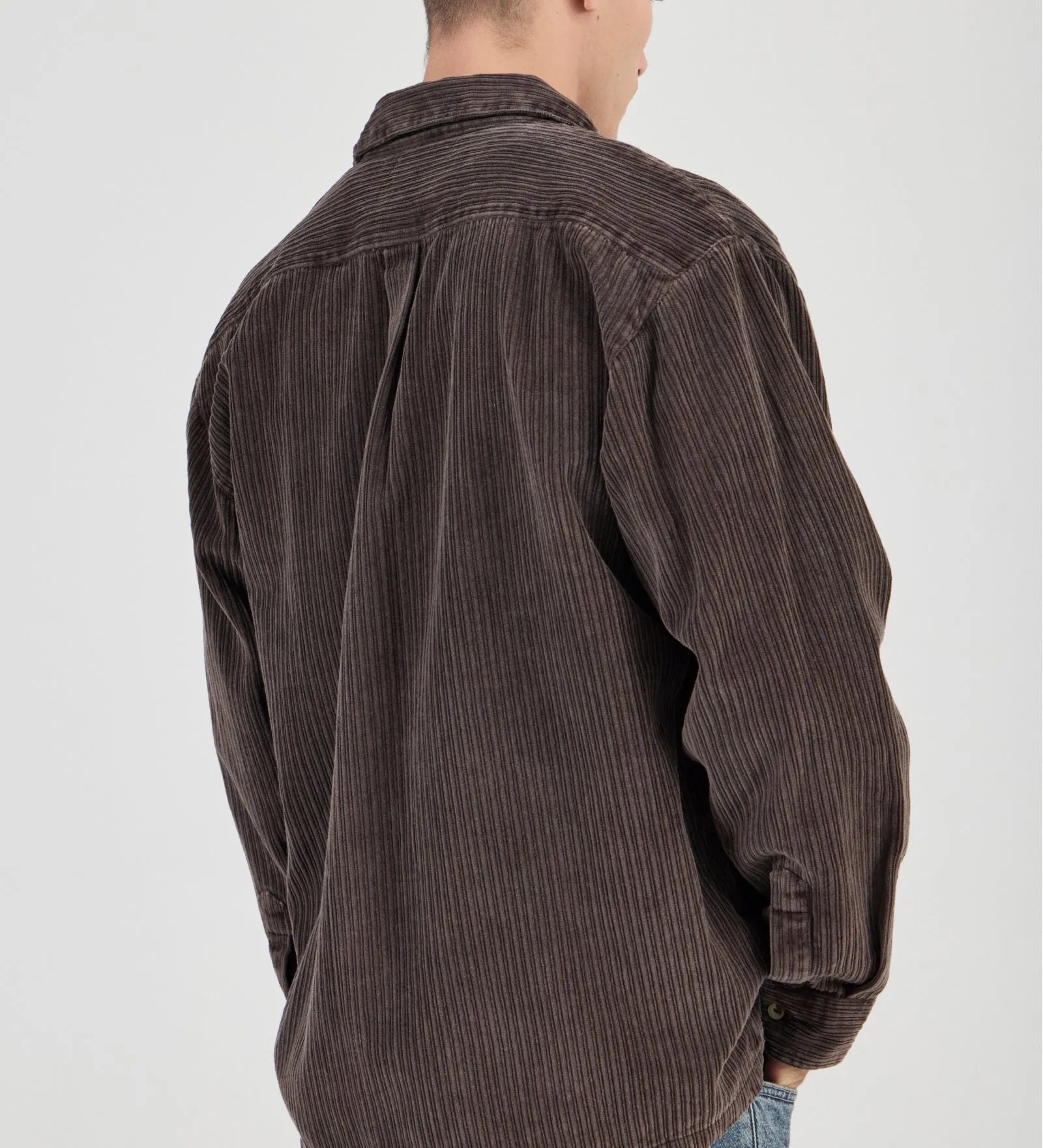 Man wearing a brown corduroy shirt on a white background
