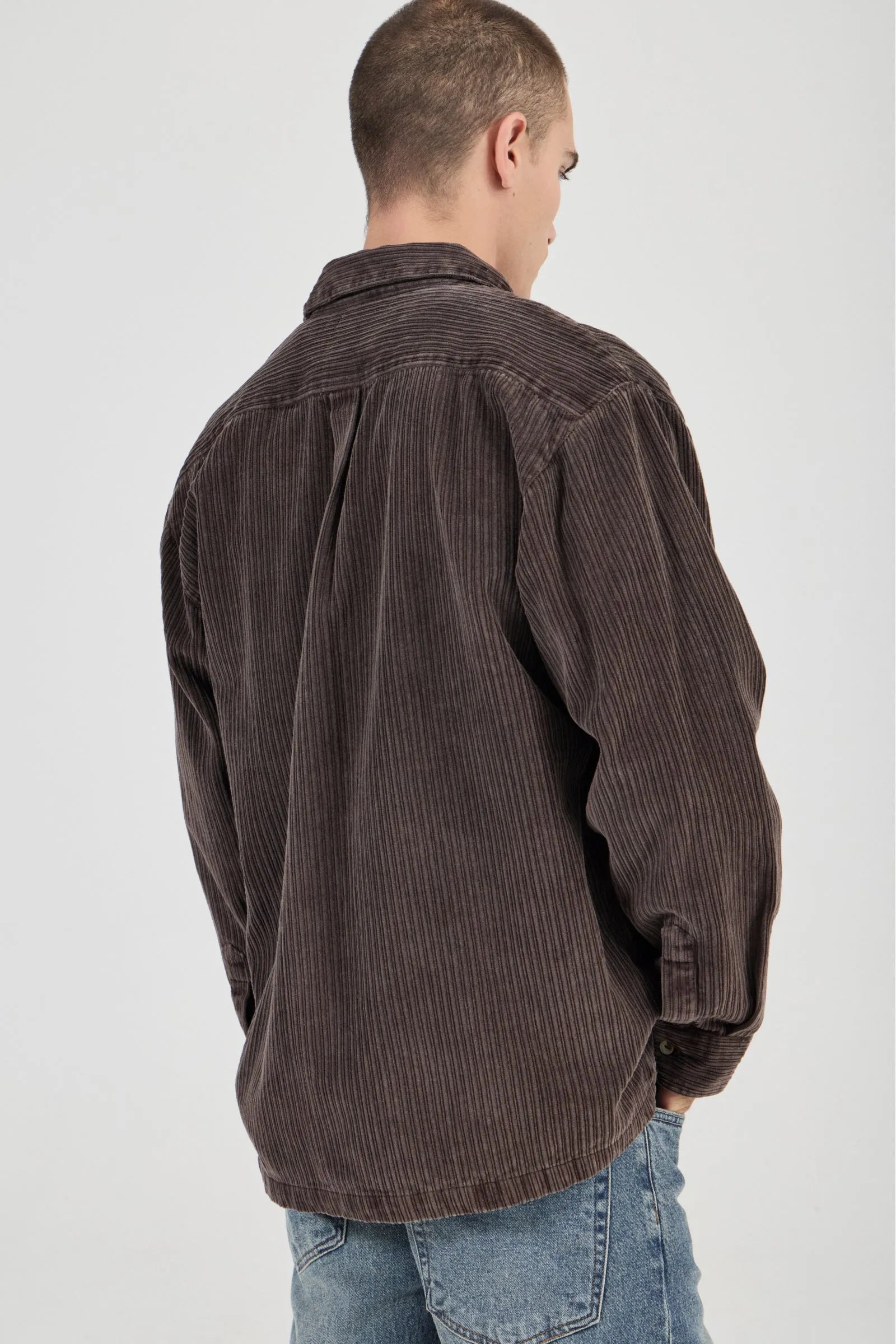 Man wearing a brown corduroy shirt on a white background