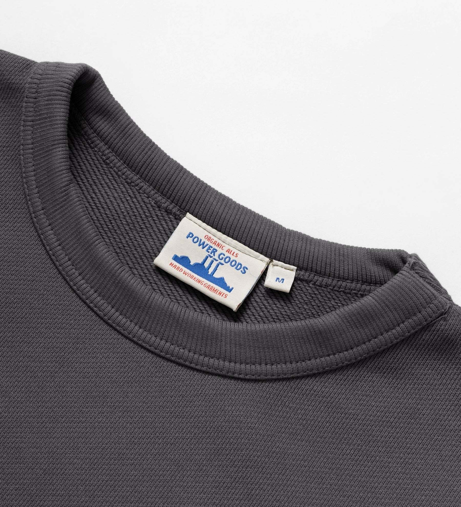 Gray sweatshirt with a visible brand label on a white background