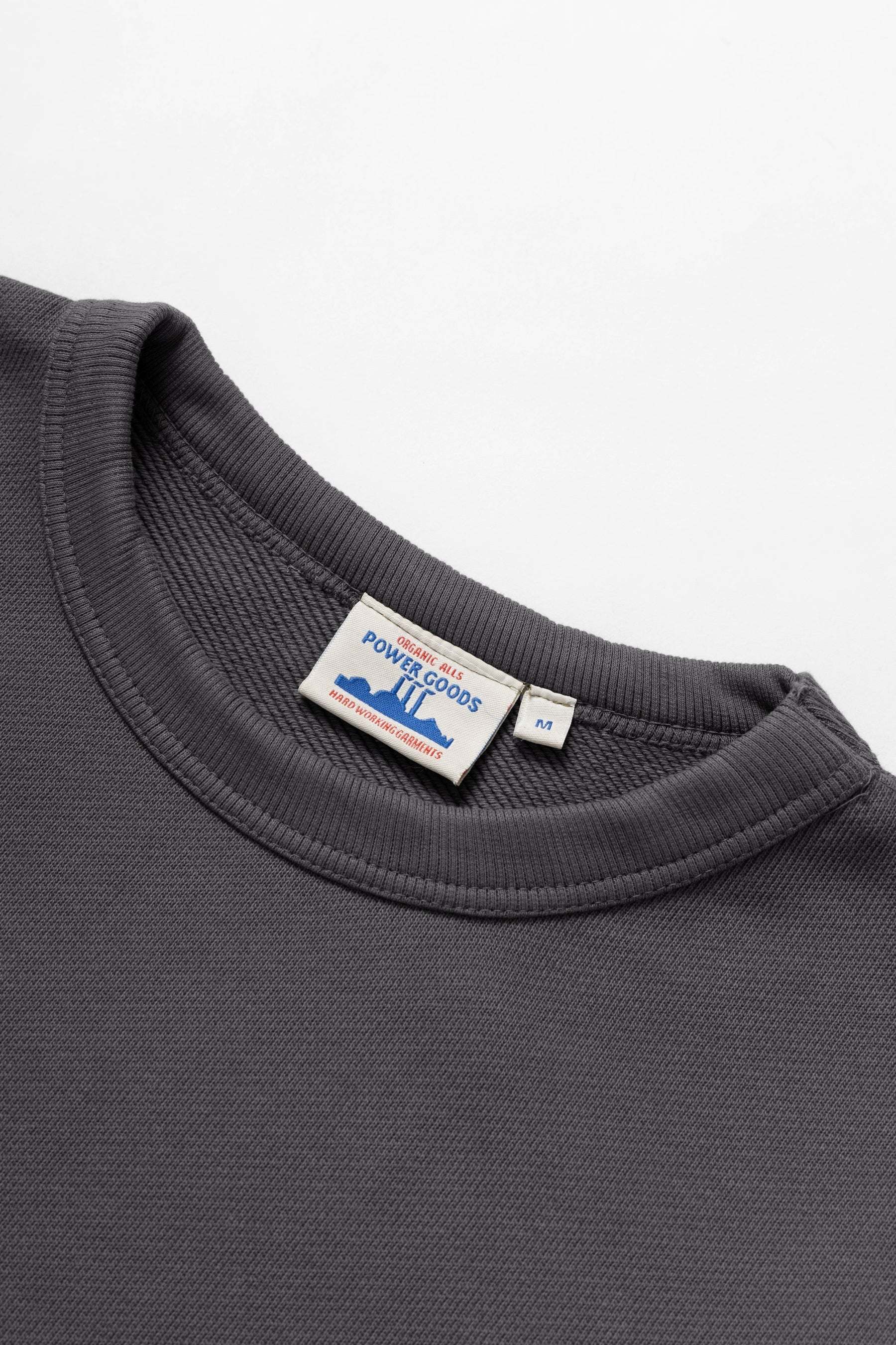 Gray sweatshirt with a visible brand label on a white background