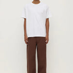 Person wearing a white t-shirt and brown pants on a white background
