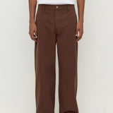 Person wearing brown pants and a white shirt on a white background