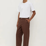 Man wearing a white t-shirt and brown pants on a white background