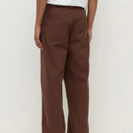 Person wearing brown pants and a white shirt on a white background