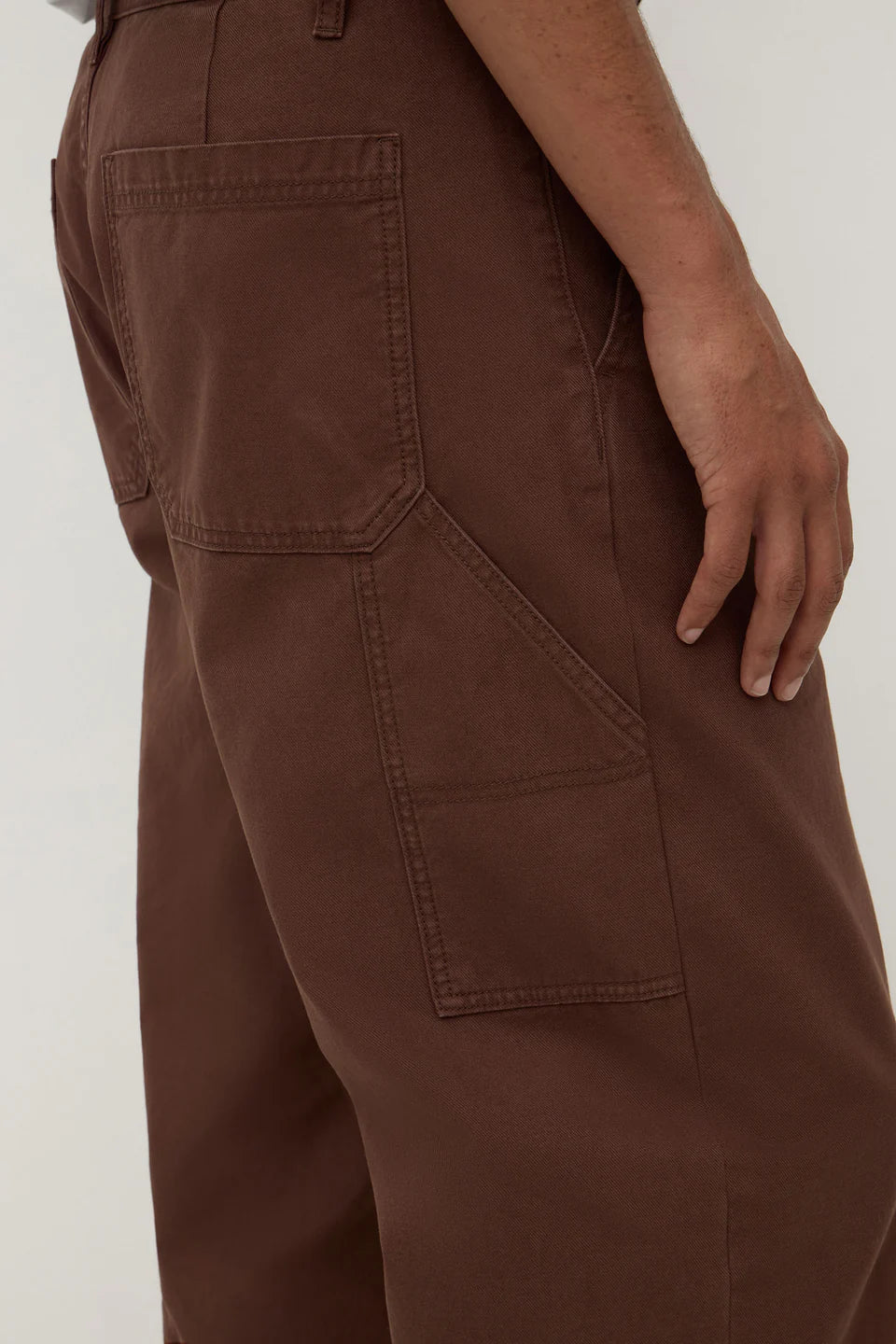 Brown pants with multiple pockets on a plain background