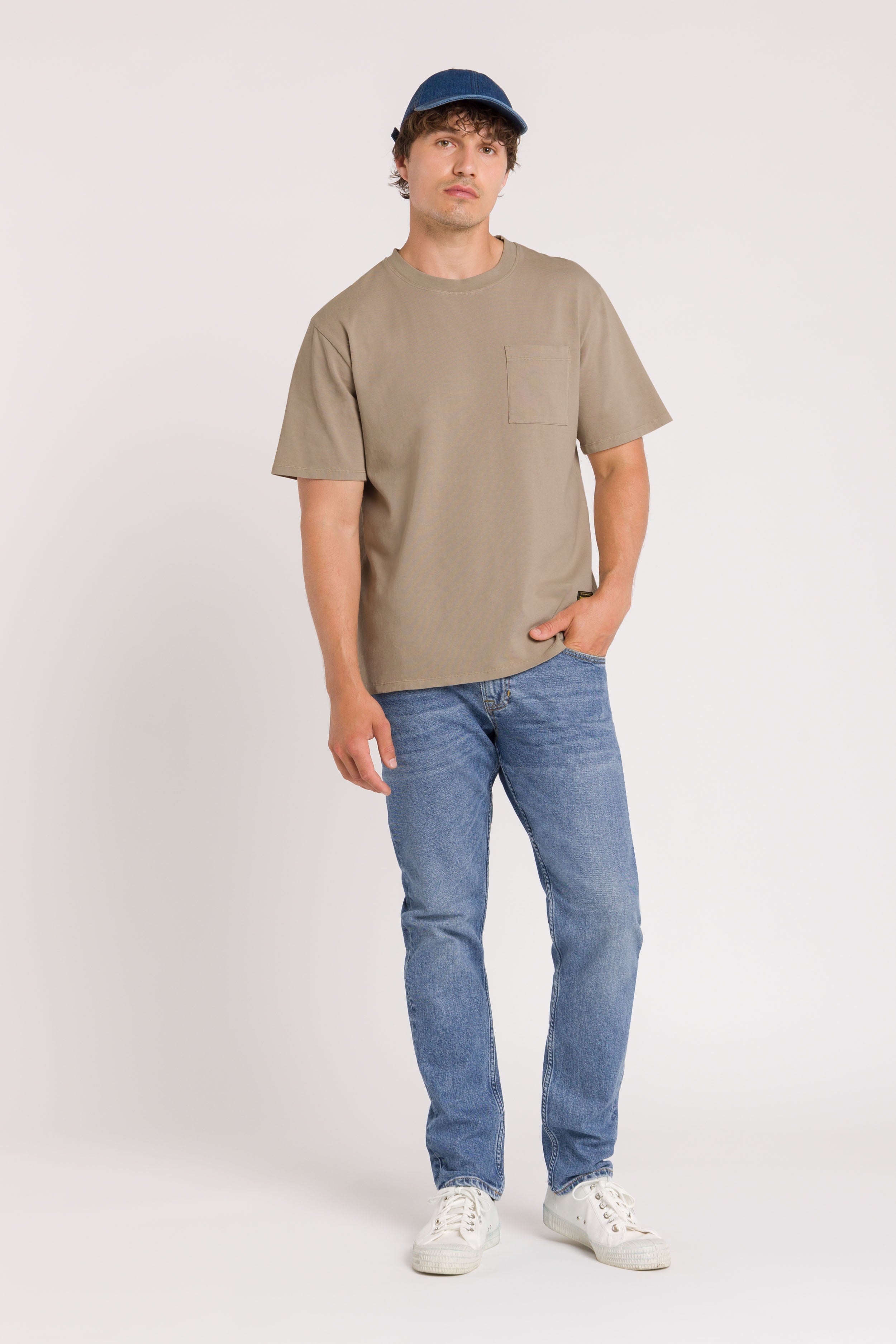 Man wearing Blue Jeans Beige top and denim cap on white Background