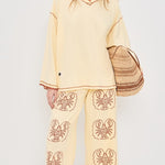 Women wearing Yellow pants with Lobster print and Yellow top in front of white background