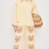 Women wearing Yellow pants with Lobster print and Yellow top in front of white background