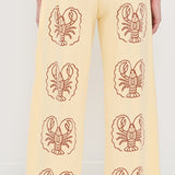 Yellow pants with lobster patterns worn by a person on a white background