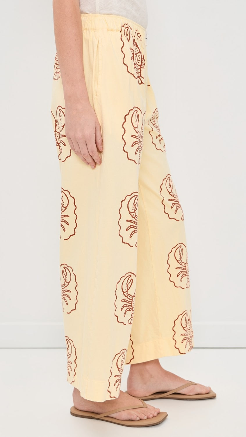 Yellow pants with Lobster pattern worn by a person on a white background