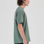 Person wearing a green t-shirt and black pants on a white background