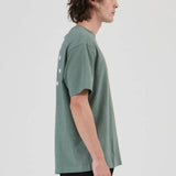 Person wearing a green t-shirt and black pants on a white background