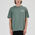 Person wearing a green t-shirt with a logo on a white background
