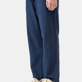 Person wearing navy blue pants with a white background