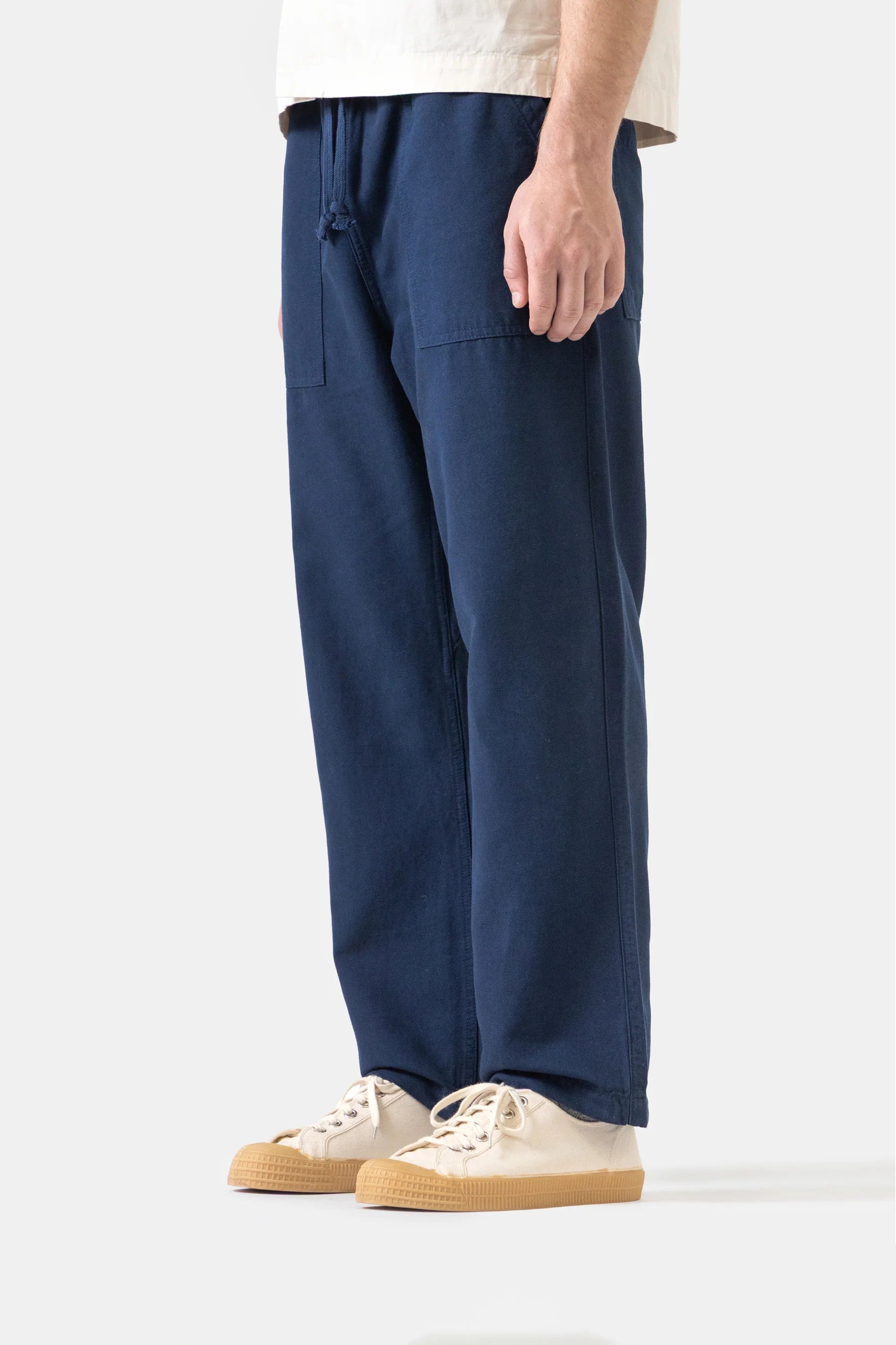 Person wearing navy blue pants with a white background