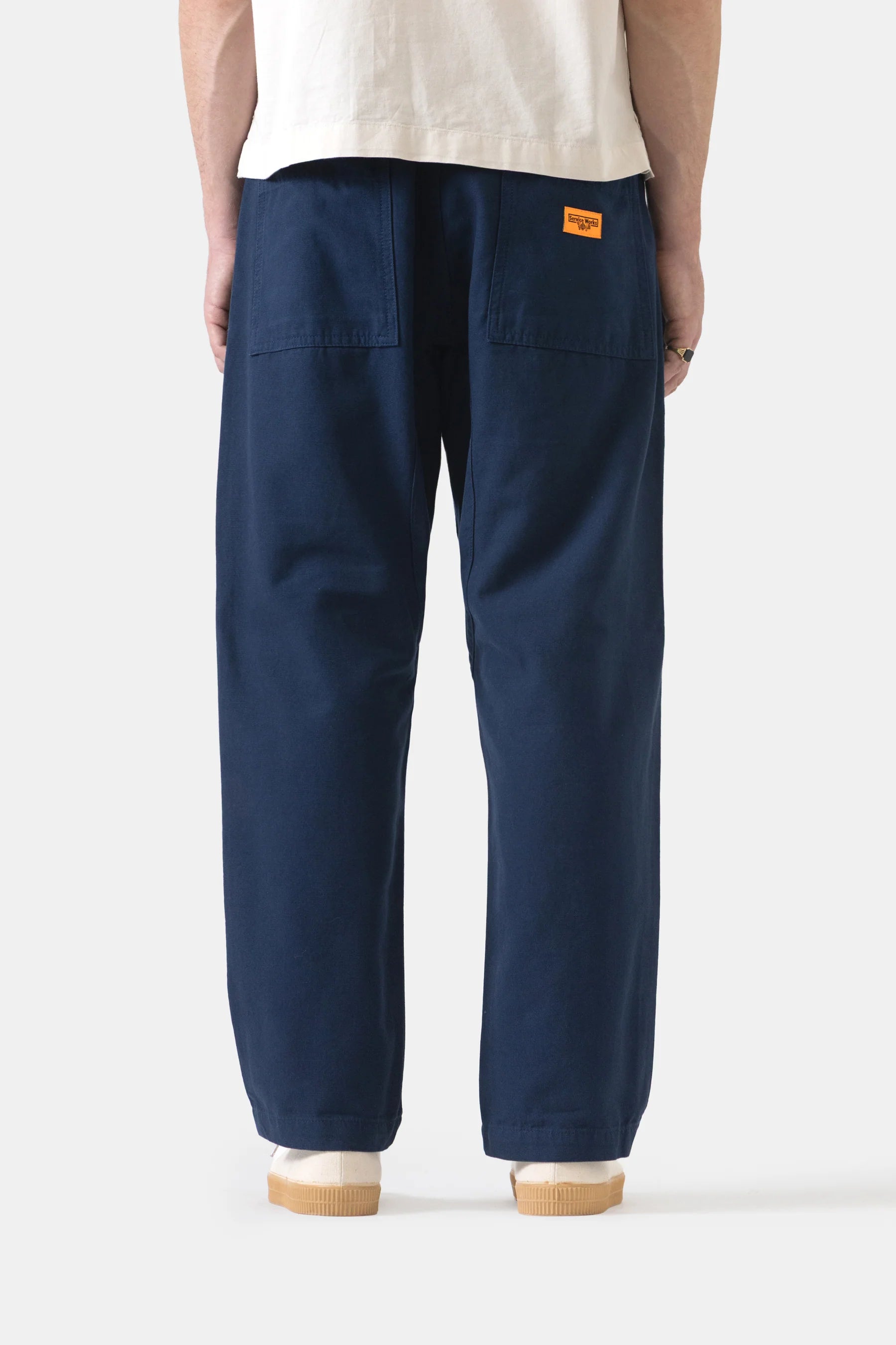 Person wearing navy blue pants with a white background