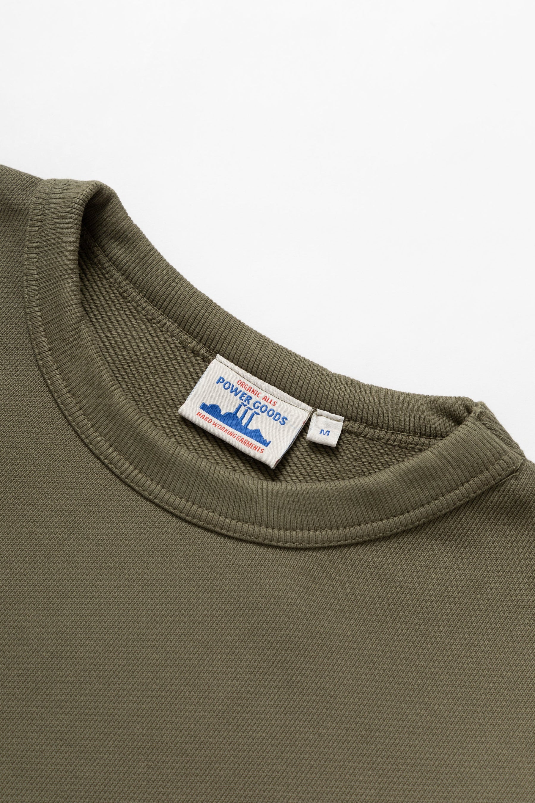 Green sweatshirt with a visible brand label on a white background