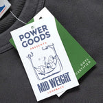 Clothing tag with 'Power Goods' branding on a gray background