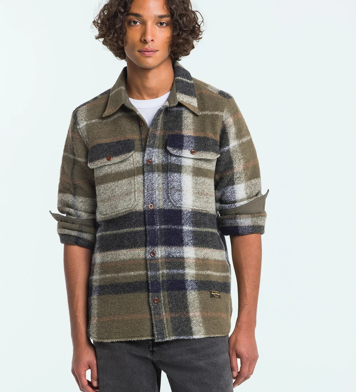 Man wearing a plaid shirt with a neutral background