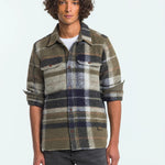 Man wearing a plaid shirt with a neutral background