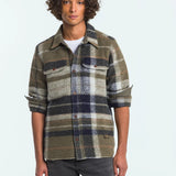 Man wearing a plaid shirt with a neutral background