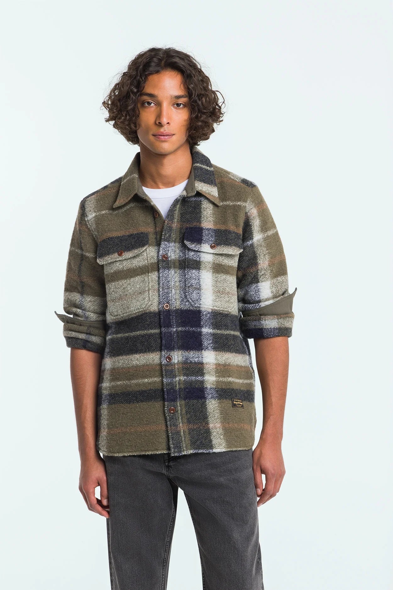 Man wearing a plaid shirt with a neutral background