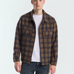 Man wearing a plaid shirt over a white t-shirt on a white background