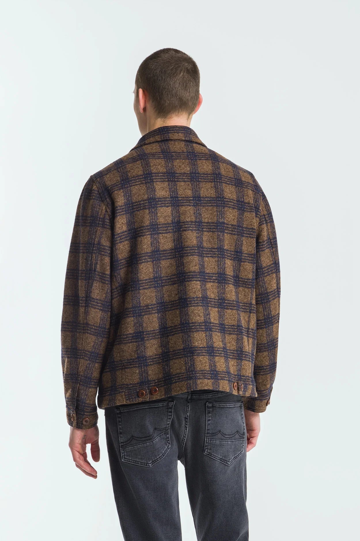 Man wearing a plaid shirt from behind on a white background