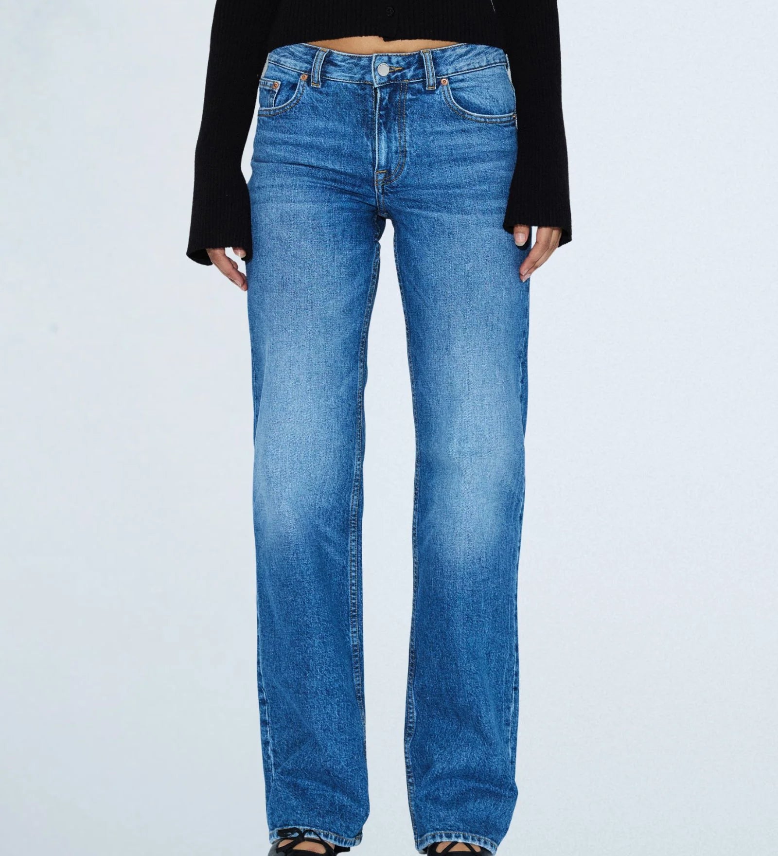 Person wearing blue jeans on a white background