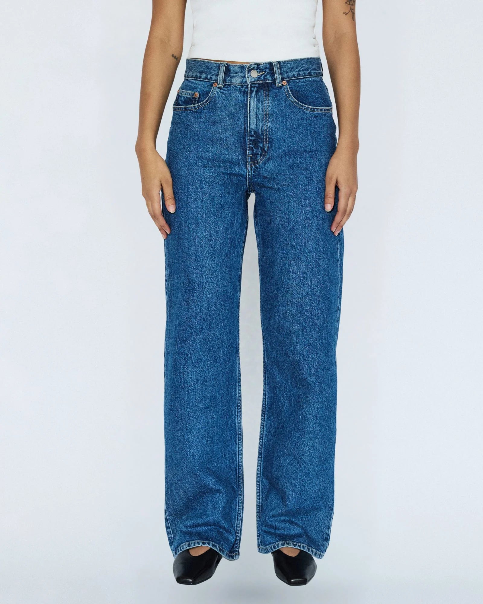 Person wearing blue jeans on a white background