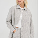 Woman wearing a gray textured jacket and skirt set on a white background