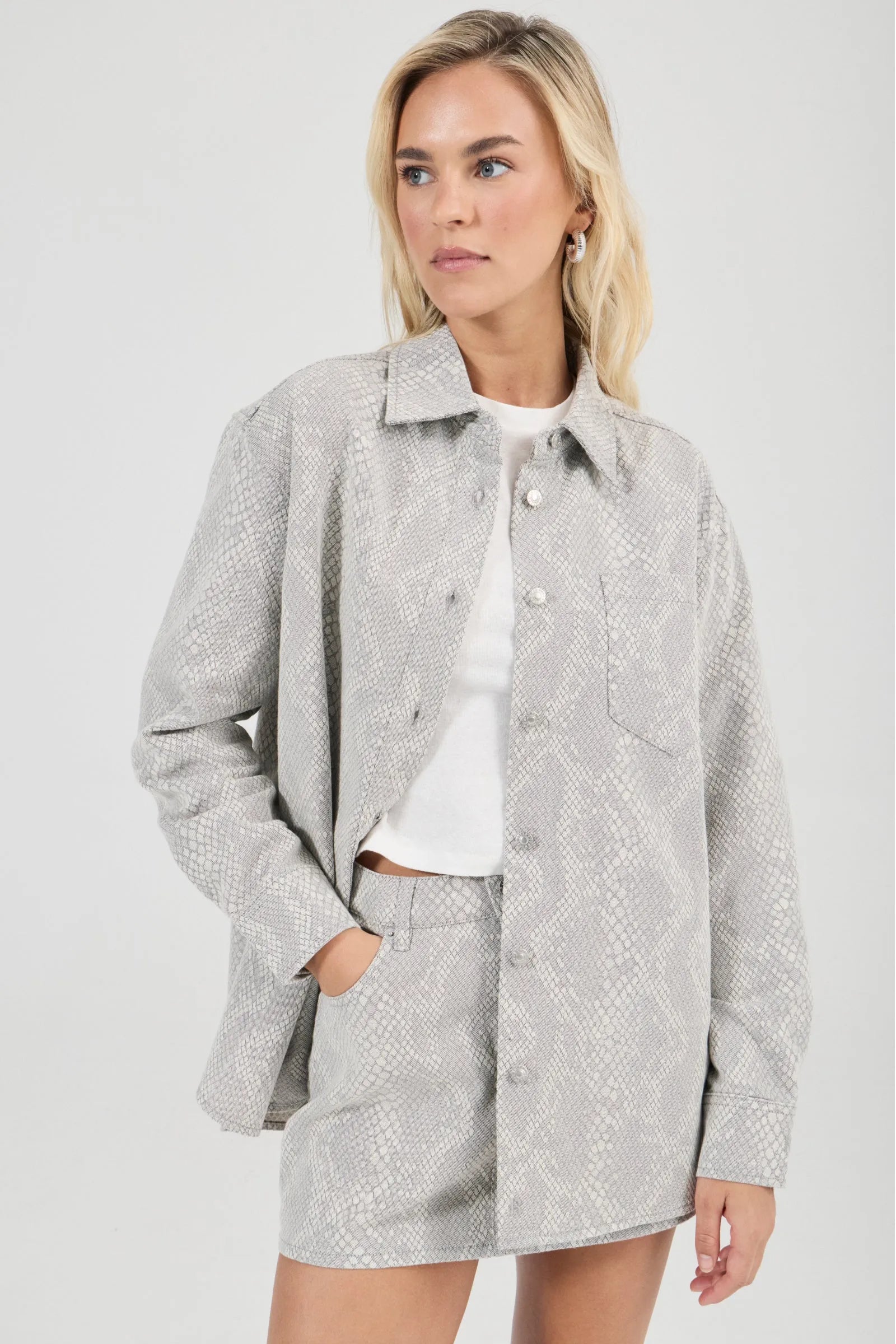 Woman wearing a gray textured jacket and skirt set on a white background