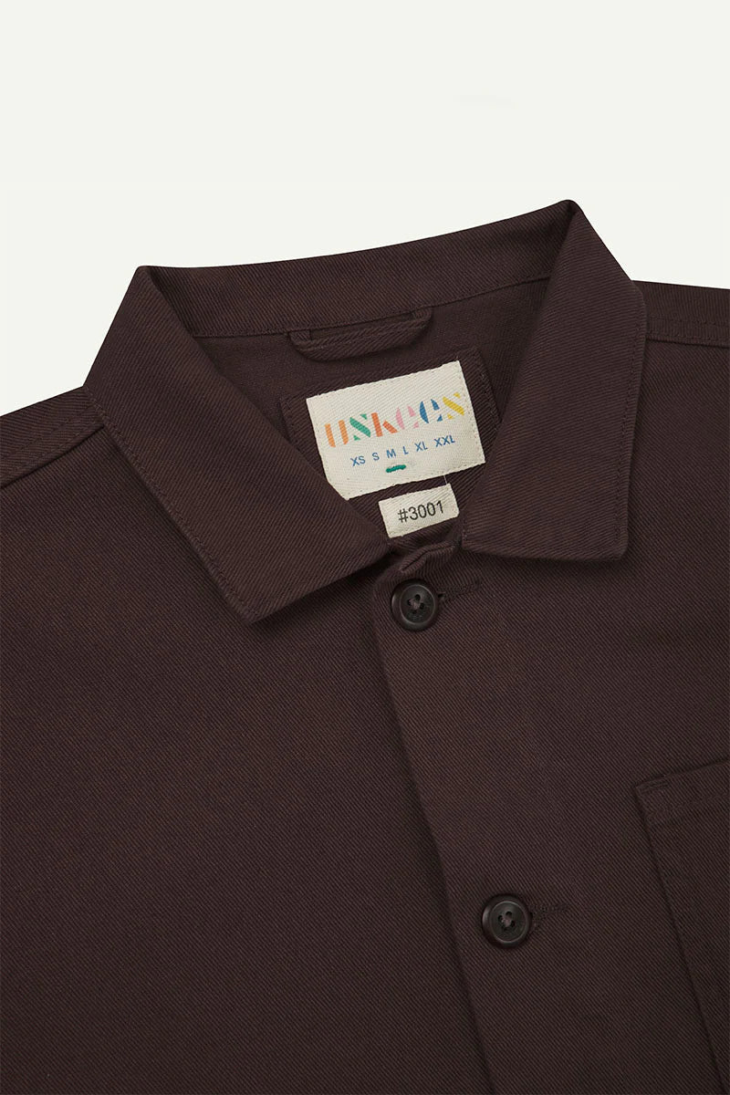 Close-up of a Dark Plum shirt collar with a label on a light gray background