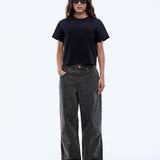 Person wearing a black t-shirt and dark jeans on a white background