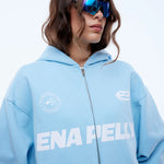 Person wearing a light blue hoodie with 'ENAPELLY' branding on a white background