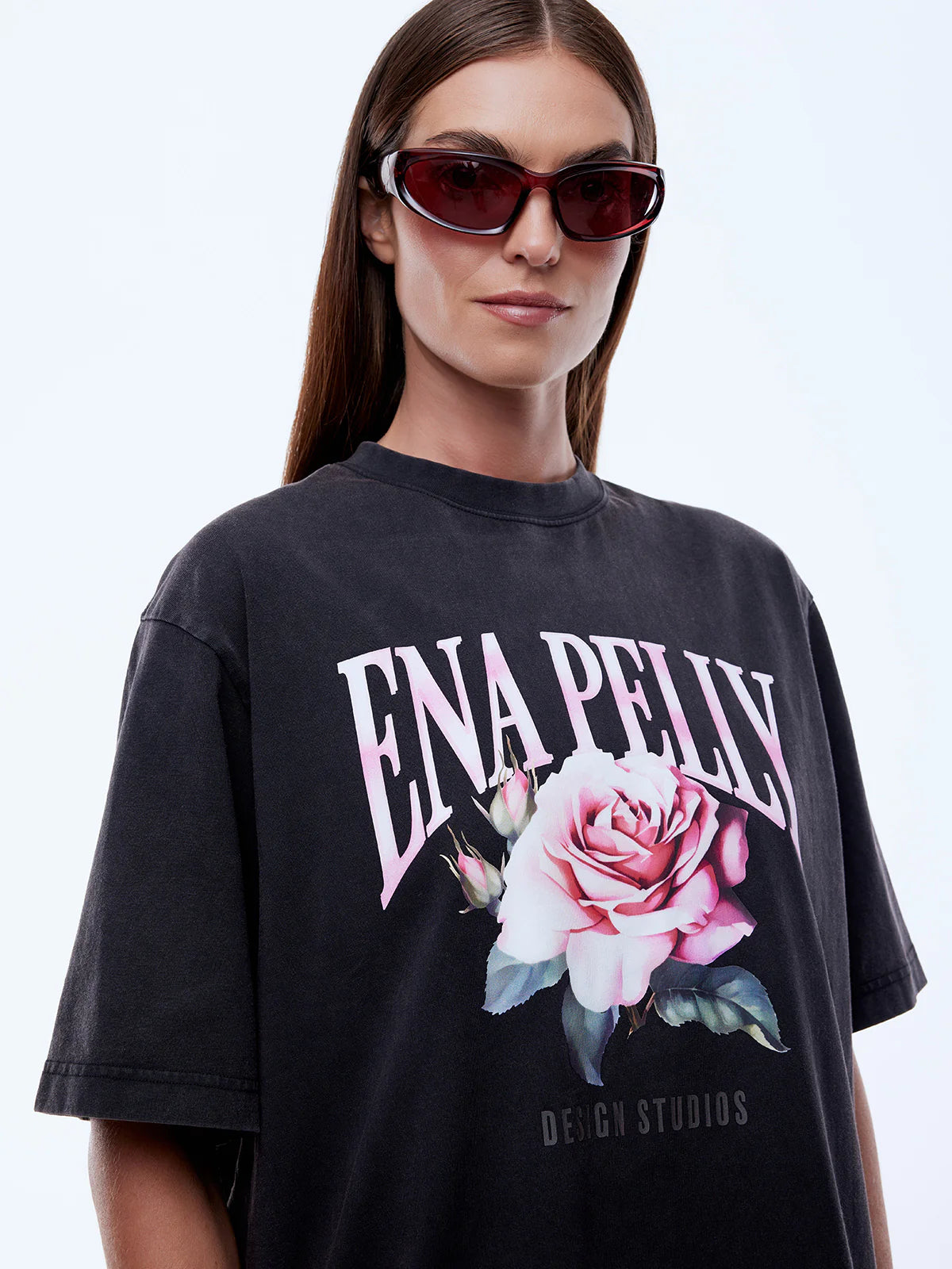 Person wearing a black t-shirt with a floral design and 'ENA PELLY' text on a white background