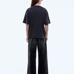 Person wearing a black t-shirt and wide-leg pants on a white background