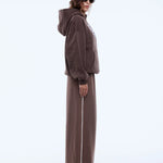 Person wearing a brown tracksuit on a white background