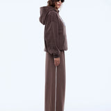 Person wearing a brown tracksuit on a white background